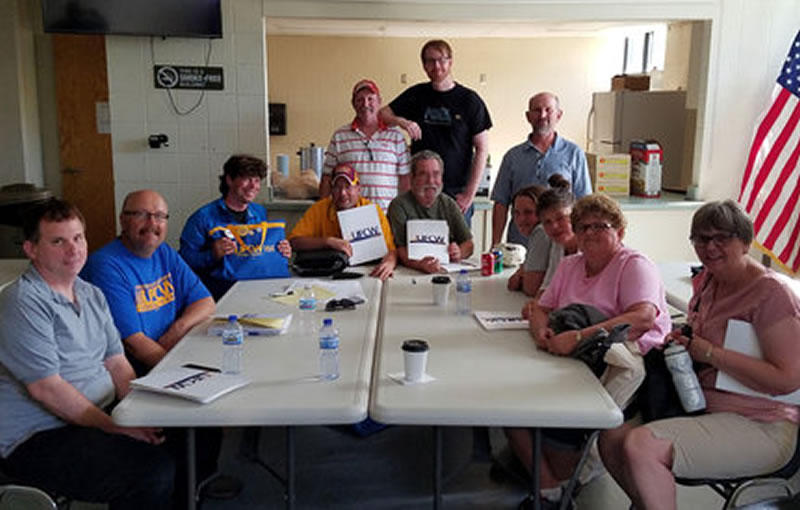 Members of the Local 1189 bargaining committee celebrated their tentative deal with northern grocers – negotiated in a dimly lit basement at the Labor Temple after storms knocked out power in the Duluth area. “Unable to print or make copies of the new offer, the groups met and documented the improvements the old fashioned way – in writing,” the union said. Photo courtesy of UFCW Local 1189.