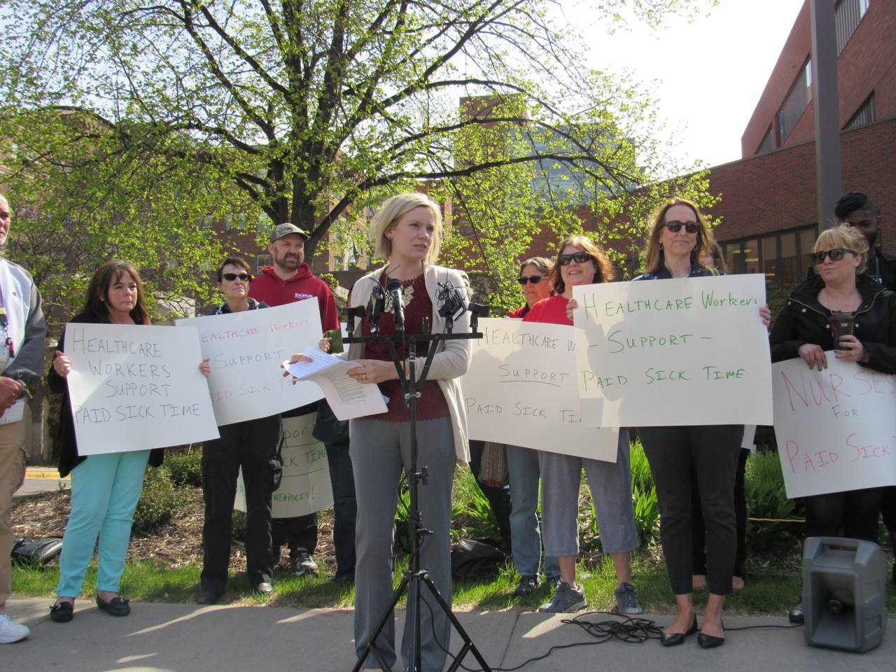 Flanked by nurses and healthcare workers, Chelsie Glaubitz Gabiou, president of the Minneapolis Regional Labor Federation, recounted her work as a member of the Workplace Partnership Group. Photo by Steve Share, Minneapolis Labor Review